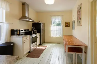 a kitchen with a table and a stove top oven at Central Picton Apartment, Sleeps 8; The Iron Horse in Picton