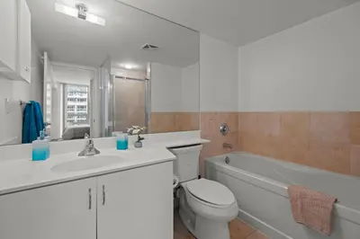 a bathroom with a toilet and a sink and a bath tub at Autumnaly Whisper 2 BR & DEN in the Heart of the City in Toronto