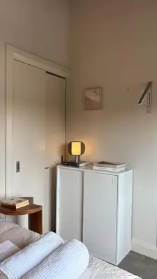 a bedroom with a bed and a table with a lamp at The Artist's Loft in Stratford