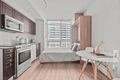 a kitchen with a bed and a table in a room at Charming Studio in Downtown Toronto in Toronto