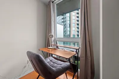 a room with a table and a chair and a window at Superior 1Bedroom&DEN Condo with Balcony in Toronto