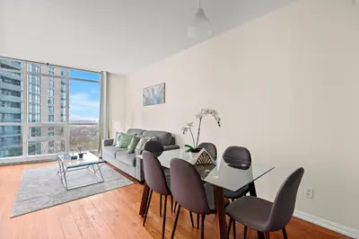 a living room with a couch and a table and chairs at Superior 1Bedroom&DEN Condo with Balcony in Toronto