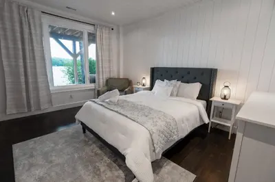 a white bedroom with a bed and a window at Butterfly Lake House | Cozy & Peaceful Stay in Port Carling