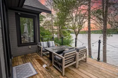 a deck with a table and chairs and a view of a lake at Butterfly Lake House | Cozy & Peaceful Stay in Port Carling
