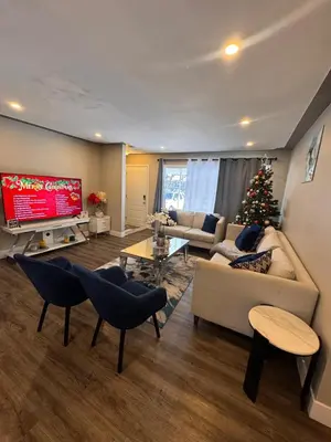 a living room with a christmas tree in the corner at Luxe Living Prime Location in Kitchener