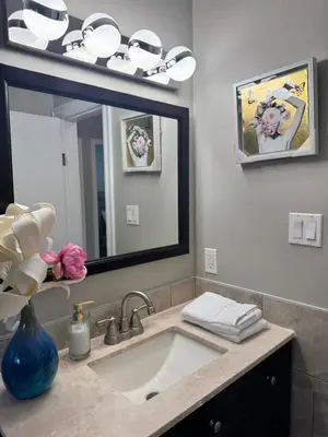 a bathroom with a sink and a large mirror at Luxe Living Prime Location in Kitchener