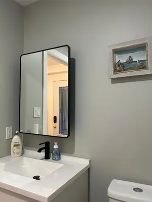 a bathroom with a mirror over a white sink at Water Front Cottage - Balsam Lake in Victoria Road