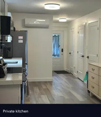 a kitchen with white walls and wooden floors and white doors at Water Front Cottage - Balsam Lake in Victoria Road