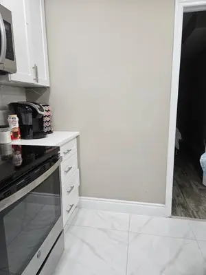 a white kitchen with a stove and a microwave at Beautiful 3 bedrooms, 2 bathrooms, 4 beds sleep 8, basement close to Falls in Niagara Falls