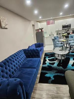 a living room with a blue couch and a table at Beautiful 3 bedrooms, 2 bathrooms, 4 beds sleep 8, basement close to Falls in Niagara Falls