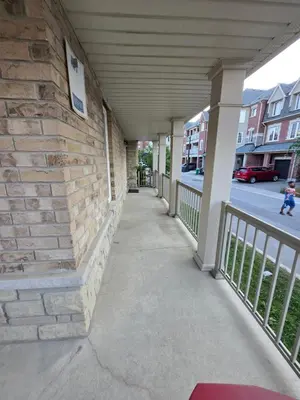 a walkway outside of a building with a brick wall at One Bed basement Room in Brampton