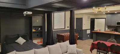 a living room with a couch and a kitchen at Modern Loft with Immersive Theatre Experience in Milton