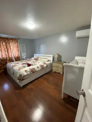 a bedroom with a bed and a wooden floor at 2-3 Bedroom Friends or Family Dwelling in Brampton