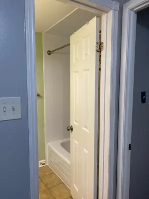 a bathroom with a tub and a white door at 2-3 Bedroom Friends or Family Dwelling in Brampton