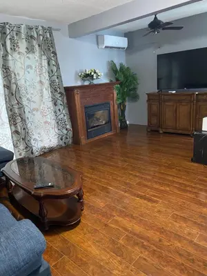 a living room with a fireplace and a tv at 2-3 Bedroom Friends or Family Dwelling in Brampton
