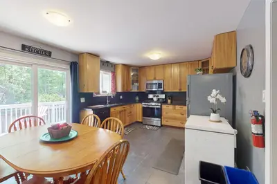 a kitchen with a table and a refrigerator at Wavy Daze Master in Wasaga Beach