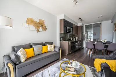a living room with a gray couch and yellow pillows at Modern Apartments 2BR 2BA Lillian St with Balcony in Toronto