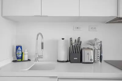 a kitchen counter with a sink with utensils at Spacious Retreat Luxe 3BR Condo with City Views in Toronto