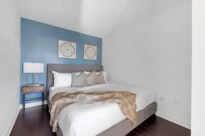 a bedroom with a large bed with a blue wall at Spacious Retreat Luxe 3BR Condo with City Views in Toronto