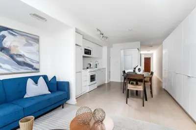 a living room with a blue couch and a table at Charming Condo w Private Patio in Quiet Capreol in Toronto