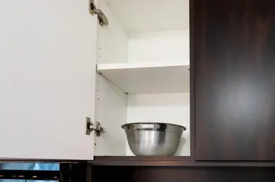 a cupboard with a large silver bowl in it at Modern 2BR in TO Near Yorkville & the Village in Toronto