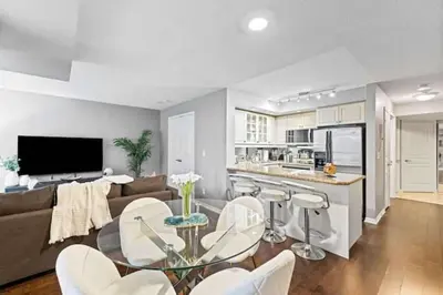 a living room with a couch and a table and chairs at Modern Oasis Stylish 2BR Condo Near Attractions in Toronto
