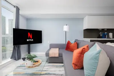 a living room with a gray couch and a tv at Toronto Getaway 2BR Condo w City Views in Toronto