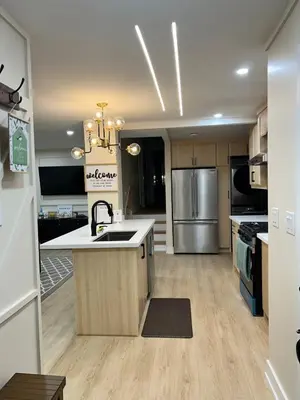 a large kitchen with a sink and a refrigerator at 3 Bedroom Home Peaceful & Trendy in Brampton