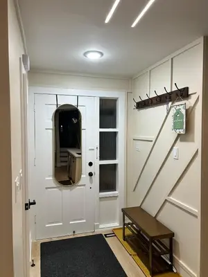 a hallway with a white door with a bench next to it at 3 Bedroom Home Peaceful & Trendy in Brampton