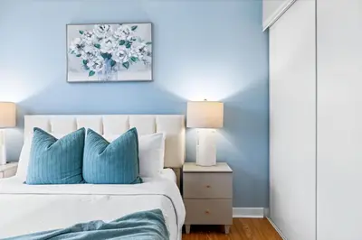 a bedroom with blue walls and a bed with blue pillows at Spacious 3BR Condo w Patio & Skyline Views in Toronto