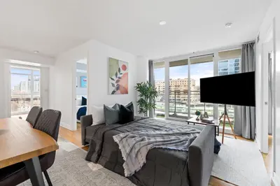 a bedroom with a bed and a flat screen tv at Spacious 3BR Condo w Patio & Skyline Views in Toronto