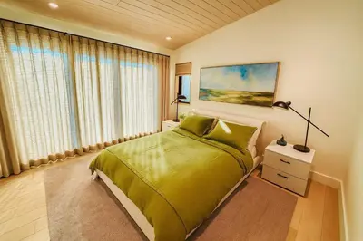 a bedroom with a green bed and a window at Stoney Lake Cottage with Private Dock by Leavetown Vacations in Crowes Landing