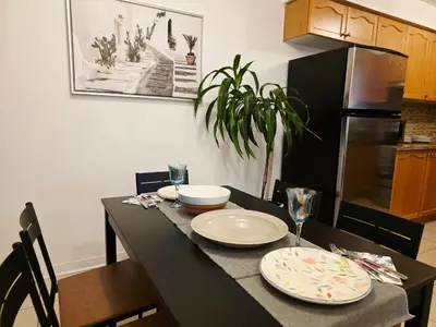 a kitchen with a black table with plates on it at Semi-Private Townhouse - 3 Bedrooms - 4 beds - Free Parking, Wifi, Netflix in Toronto