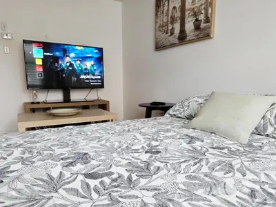 a bedroom with a bed and a flat screen tv at Semi-Private Townhouse - 3 Bedrooms - 4 beds - Free Parking, Wifi, Netflix in Toronto