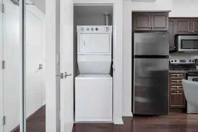 a kitchen with a refrigerator and a stove at Stylish Condo with Private Patio in Fortyork in Toronto