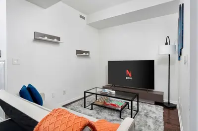 a living room with a tv and a couch at Stylish Condo with Private Patio in Fortyork in Toronto