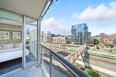 a balcony with a bed and a view of a city at Spacious Toronto Condo w Patio - City Comfort in Toronto