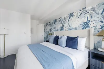 a bedroom with a bed with blue and white pillows at Stylish 2BR Downtown Escape Prime Victoria Spot in Toronto