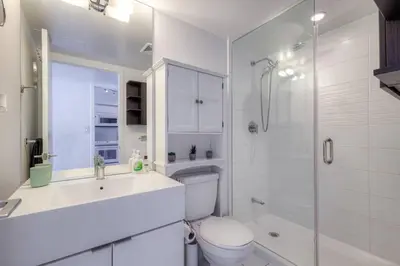 a white bathroom with a toilet and a shower at Modern 2 Bedroom plus Den Condo with Balcony Downtown Toronto in Toronto