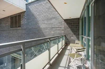 a balcony with two chairs and a brick wall at New Modern 2 Bedroom 2 Bath Apartment with Balcony in Toronto
