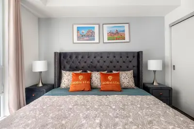 a bedroom with a large bed with orange pillows at New Modern 2 Bedroom 2 Bath Apartment with Balcony in Toronto