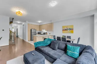 a living room with a couch and a kitchen at Chic Open-Concept 5 Beds Home by Airport and Highways in Brampton