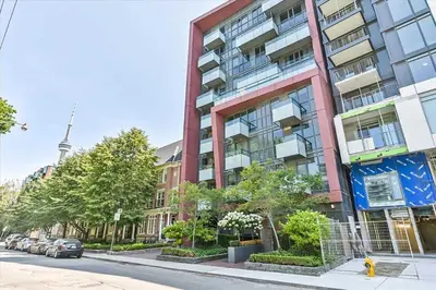 a tall building on a city street with cars parked at Luxury 2-Story loft in downtown in Toronto