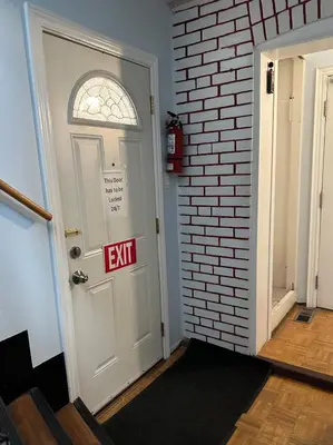 an exit sign on a door with a brick wall at Relax in East York Space Share in Toronto