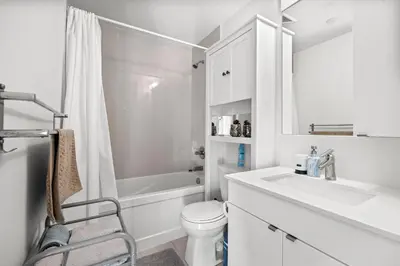 a white bathroom with a toilet and a sink at Modern New 2Bd 2Ba &Den Condo with Balcony in Toronto