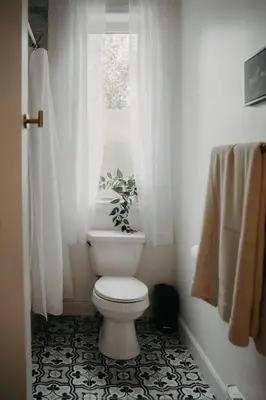 a bathroom with a white toilet and a window at The Hideout in Barrie