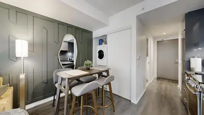a living room with a table and chairs and a mirror at Cozy 1BR Condo in Core Toronto in Toronto