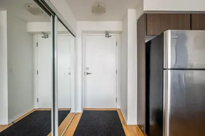 a kitchen with a refrigerator and a hallway at 1BR High Floor View Downtown Toronto in Toronto