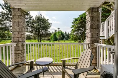 a screened porch with two chairs and a table at Perfect Jacuzzi Suite at Highland in Shanty Bay