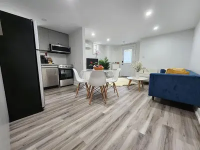 a living room with a table and a blue couch at Entire 2BR Apt in Midtown Toronto, walk to Subway & Shops in Toronto